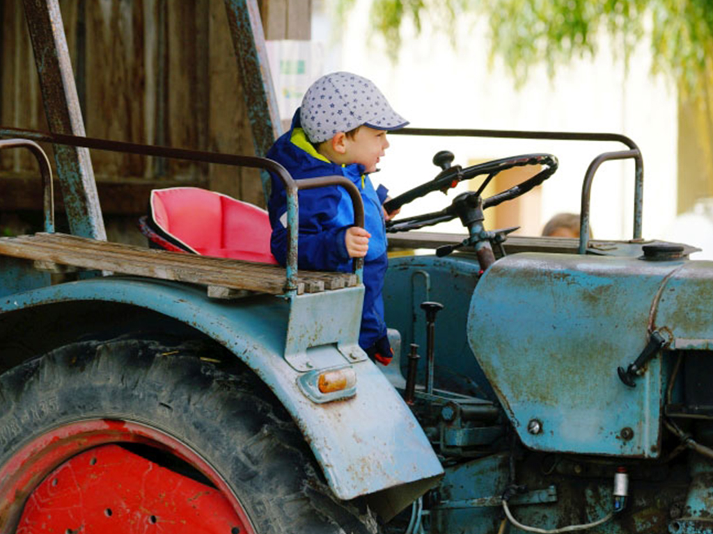 kleinkind sitzt auf dem traktor