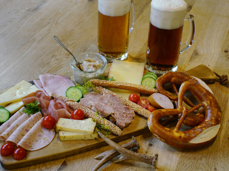 fränkische brotzeit auf holzbrett mit brezel und bier