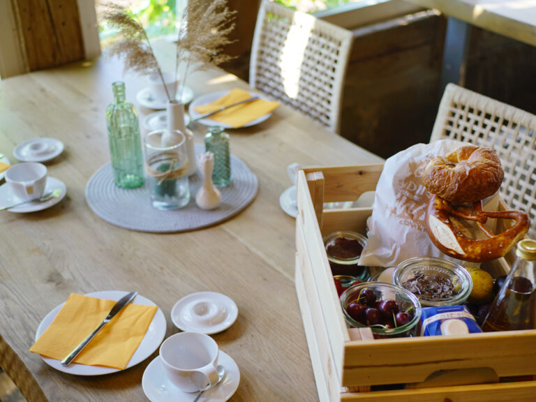 Frühstückstisch gedeckt mit gefüllter Frühstückkiste
