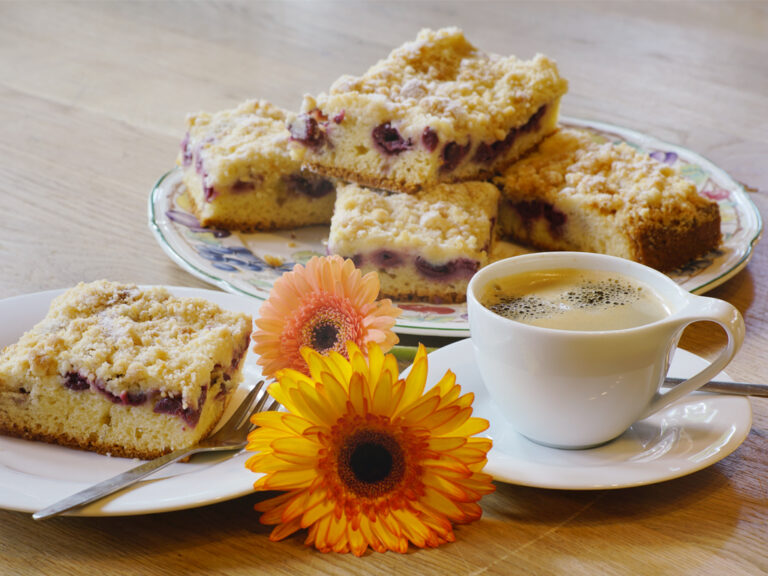 kirschstreuselkuchen auf teller mit tasse kaffee