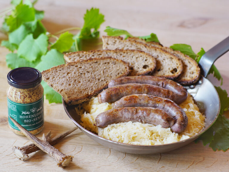 pfanne mit wildbratwurst sauerkraut brot und senf