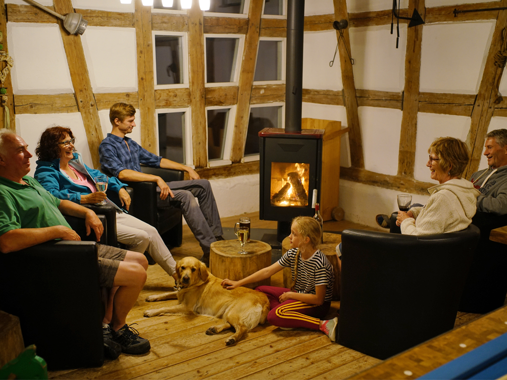 brennender kamin mit mehreren personen davor sitzend