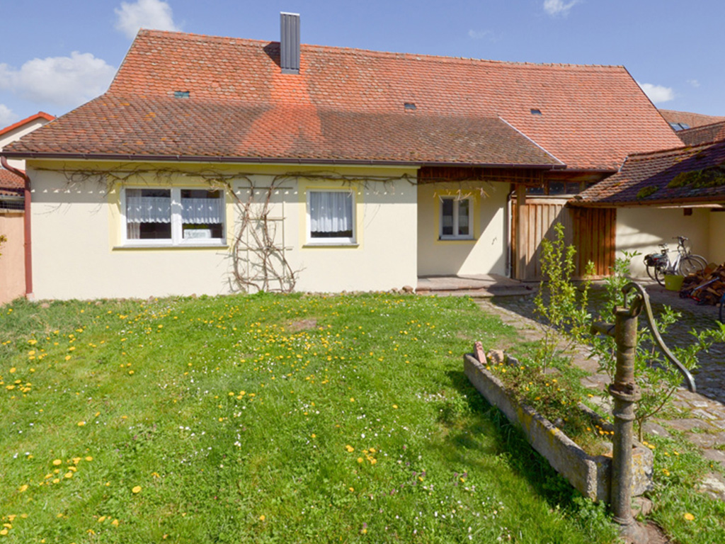 ferienhaus kornblume aussenaufnahme mit wiese und alte wasserpumpe