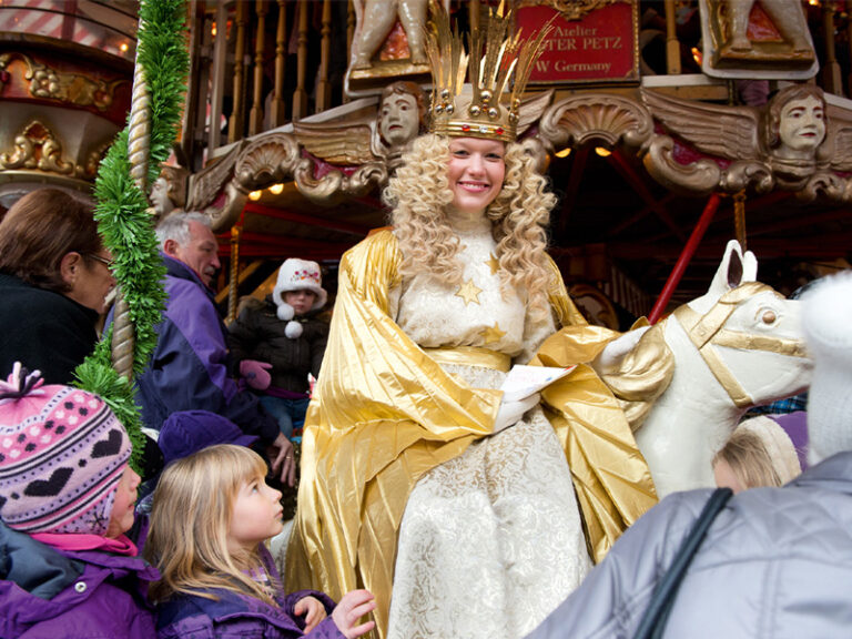 Nürnberger Weihnachtsmarkt Christkind sitzt auf einem Pferd des Nostalgie-Karussell