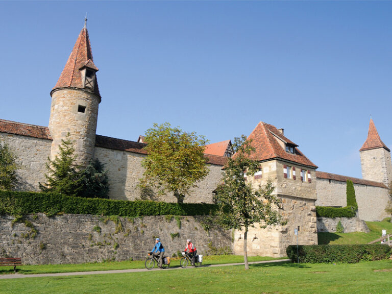 fahradfahrer fahren an der Stadtmauer von Rothenburg entlang