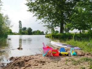 Sandspielzeug und Surfbrett am Badeweiher Binzwangen